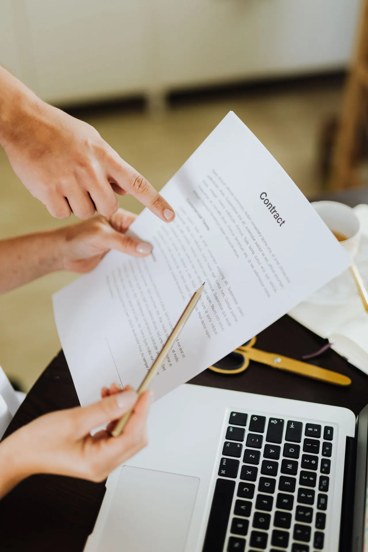 Consultants reviewing documents beside a laptop
